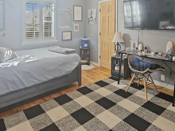 a bedroom with a bed a dresser and a window