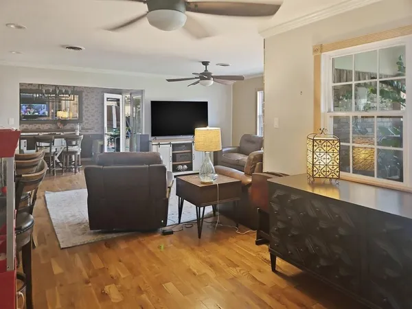 a living room with furniture a flat screen tv and a large window
