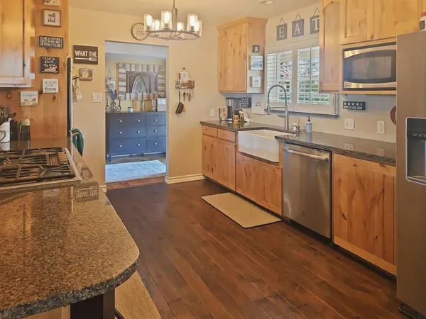 a kitchen with stainless steel appliances granite countertop a sink and wooden cabinets
