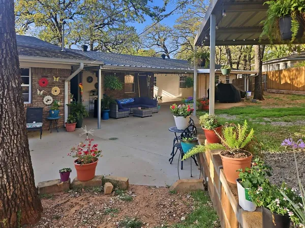 a view of a patio with table and chairs potted plants