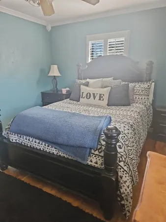a bed sitting in a bedroom next to a window with lamp