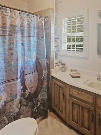a bathroom with a granite countertop sink mirror vanity and toilet
