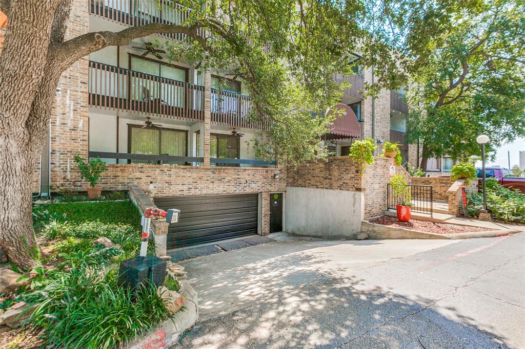 6122 Ridgecrest Road, Unit 2007 Dallas, TX 75231 - Photo 1 of 13 View of front of home with brick siding, concrete driveway, a garage, and a balcony