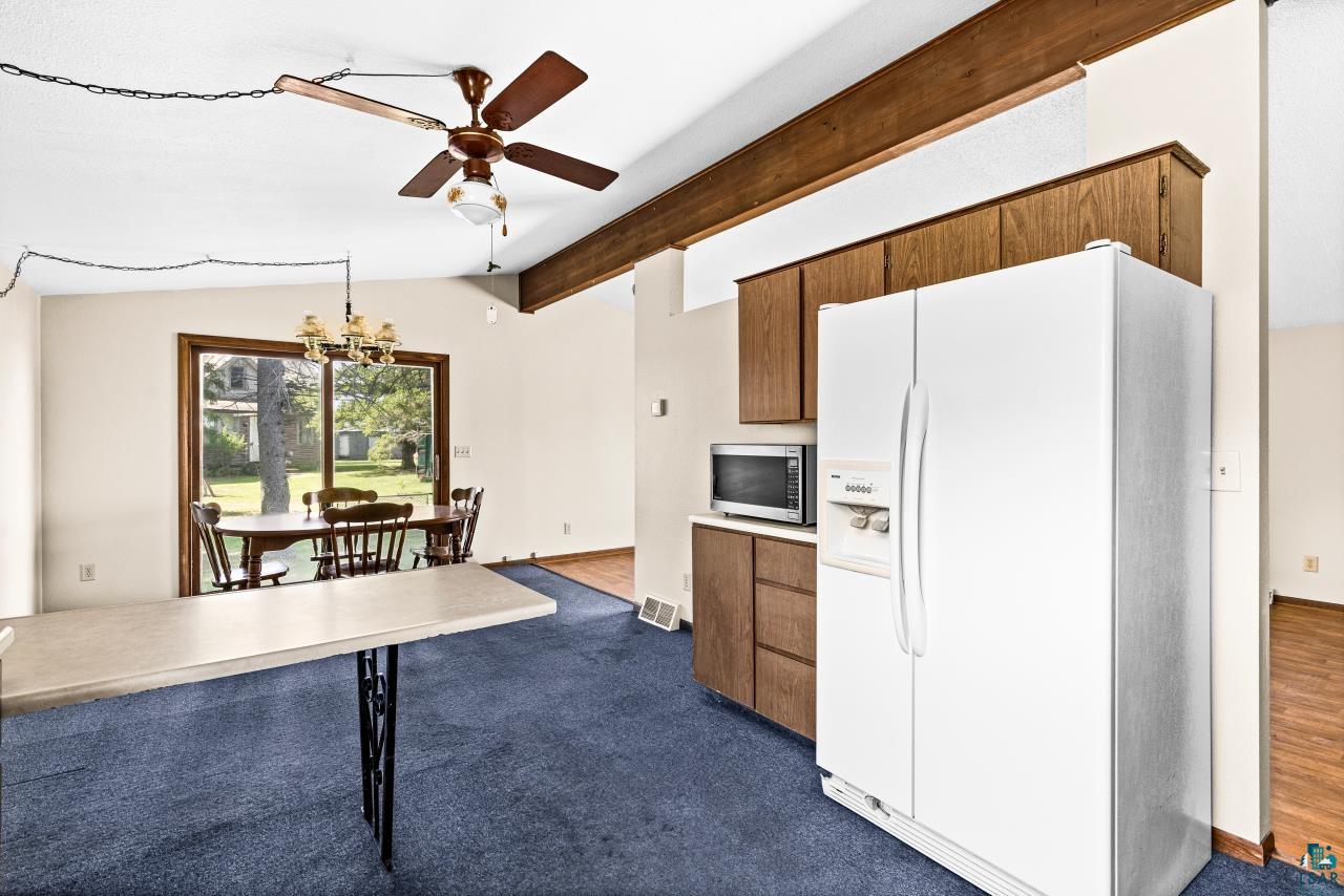 6606 Metso Road Kettle River, MN 55757 - Photo 19 of 84 Vaulted ceiling with exposed wood-finish beam, ceiling fan, and chandelier lighting