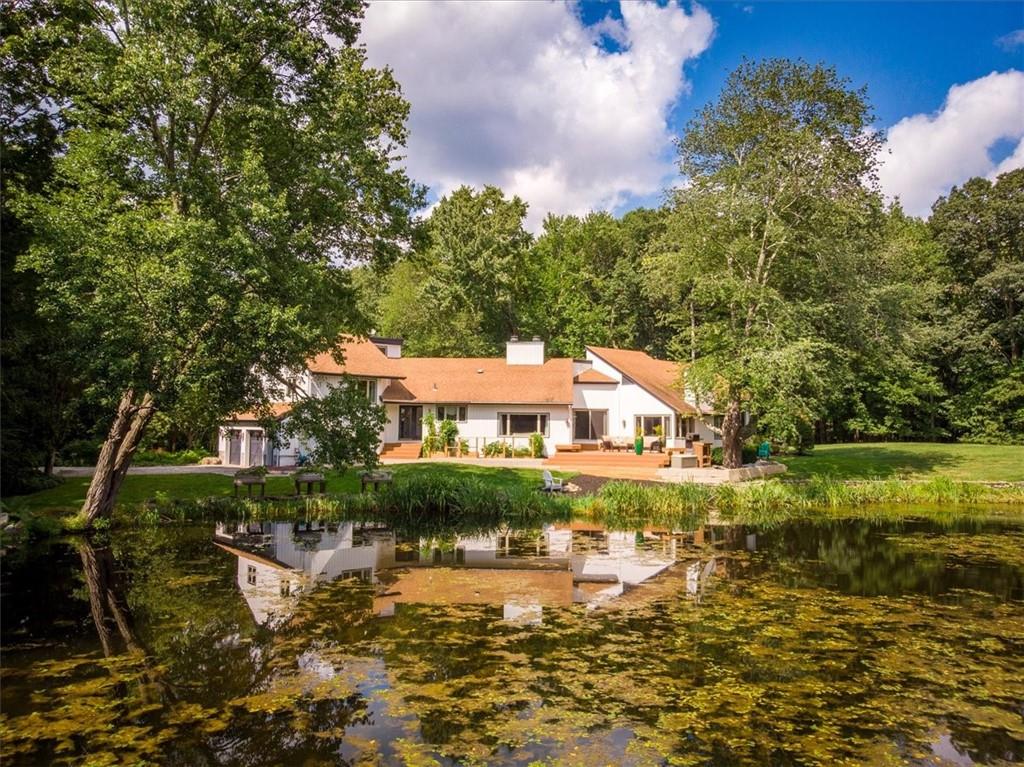 122 Old Stone Hill Road Pound Ridge, NY 10576 - Photo 1 of 1 a view of a lake with a house in the background