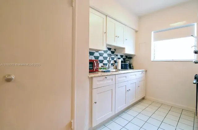 a room with white cabinets and window