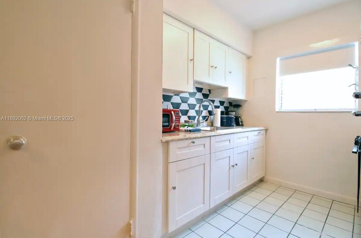 7721 Harding Avenue, Unit 9 Miami Beach, FL 33141 - Photo 8 of 10 a room with white cabinets and window