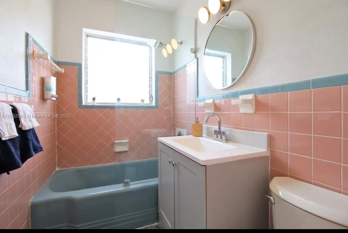 7721 Harding Avenue, Unit 9 Miami Beach, FL 33141 - Photo 10 of 10 a bathroom with a sink toilet and a mirror