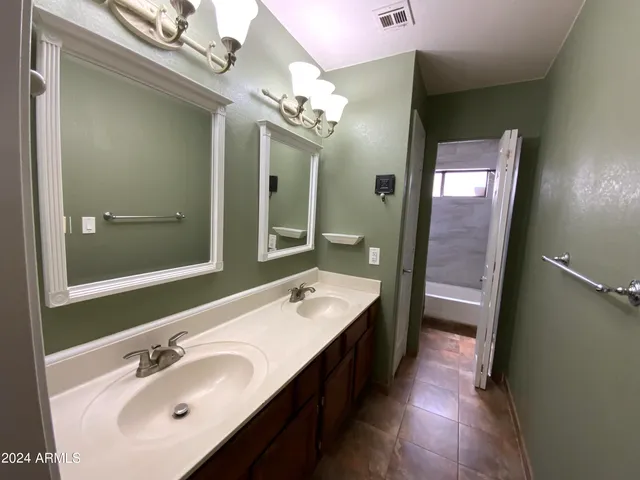 a bathroom with a double vanity sink and a mirror