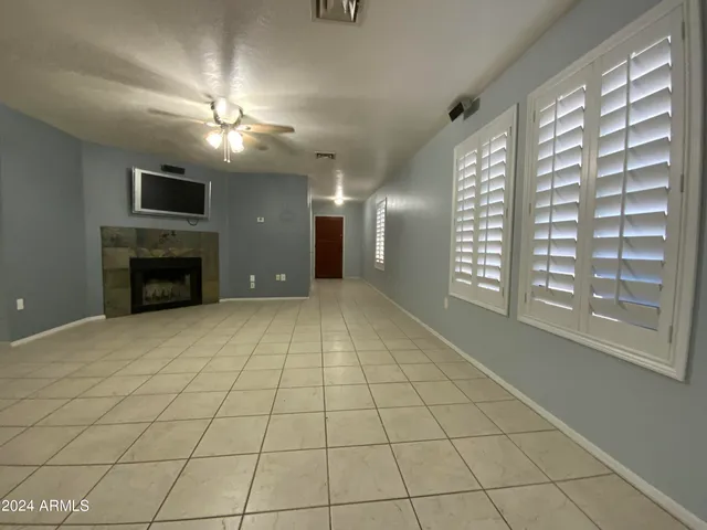 a view of an empty room with a fireplace and a window