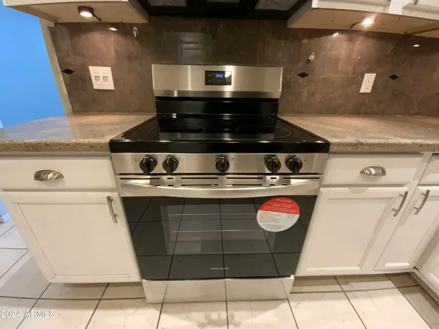 a stove top oven sitting inside of a kitchen