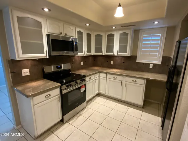 a kitchen with a sink stove top oven and cabinets