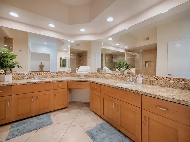 a bathroom with double vanity and a mirror