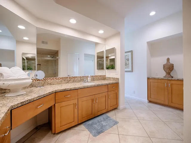 a bathroom with a granite countertop sink and a mirror