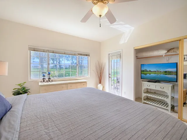 a spacious bedroom with a bed and a flat screen tv