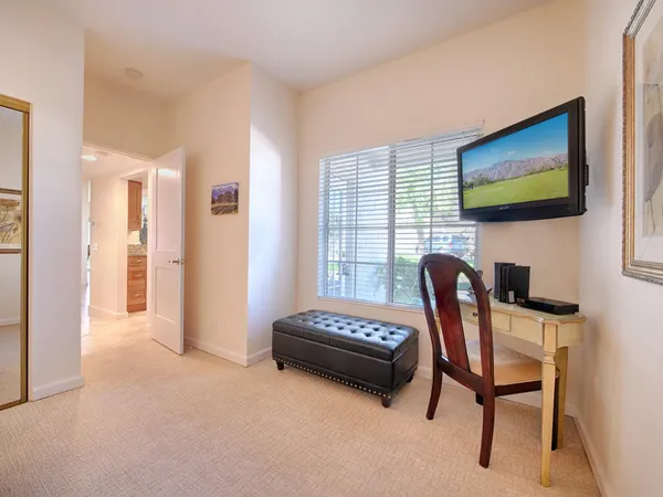 a living room with furniture a flat screen tv and a window