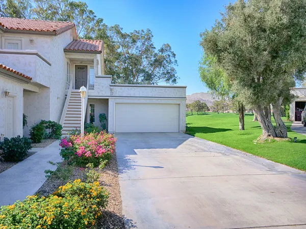 a front view of a house with a yard and a garage