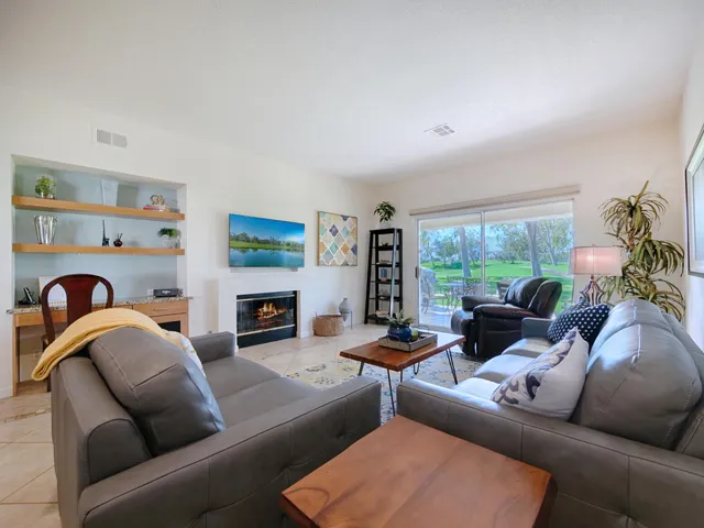 a living room with furniture a fireplace and a large window