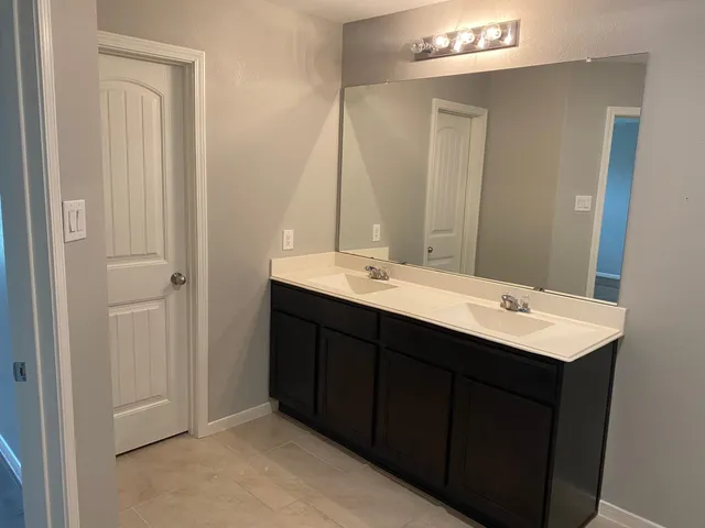 a bathroom with a double vanity sink and a mirror
