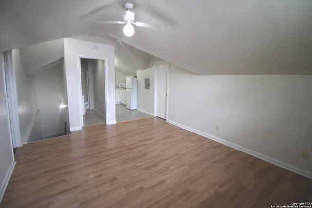a view of empty room with wooden floor