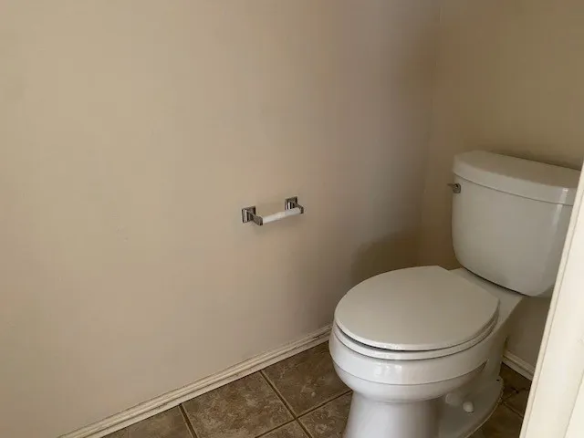 a white toilet sitting next to a white wall