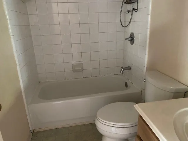 a white toilet sitting next to a bath tub and a shower