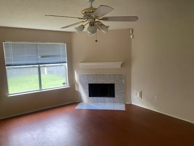 an empty room with windows and fireplace
