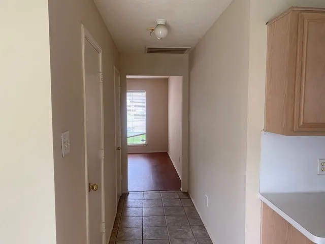 a view of a hallway with wooden floor