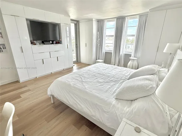 a spacious bedroom with a bed and a night stand