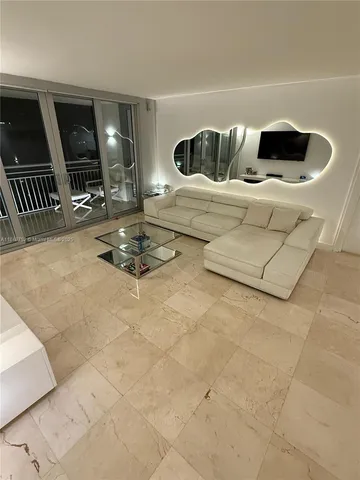 a living room with furniture a flat screen tv and a large window