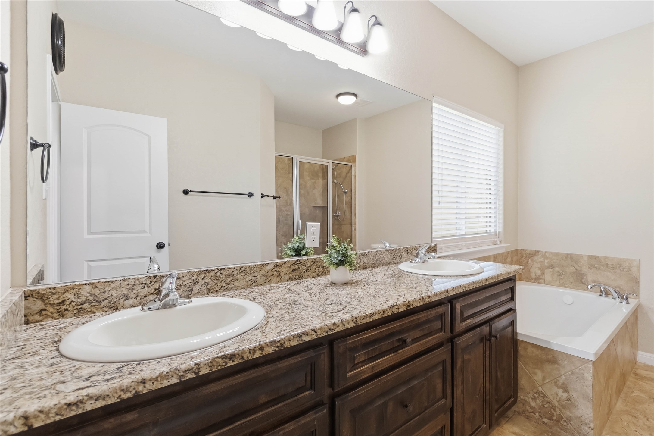 285 Hummingbird Way Martindale, TX 78655 - Photo 21 of 40 a bathroom with a granite countertop double vanity and a mirror
