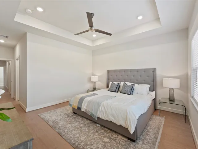 a bedroom with a large bed and a chandelier