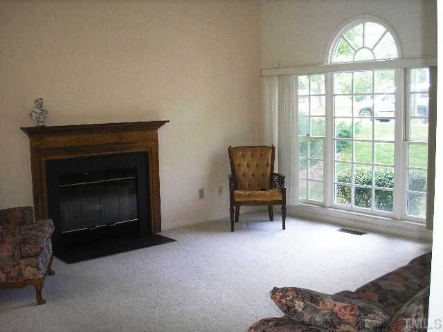 6301 Cape Charles Drive Raleigh, NC 27617 - Photo 4 of 19 a living room with furniture a fireplace and a large window