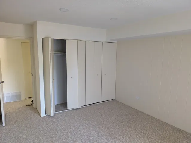 a view of a patio with couches table and chairs with wooden floor and fence