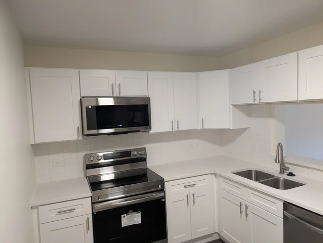 a kitchen with sink a microwave and cabinets