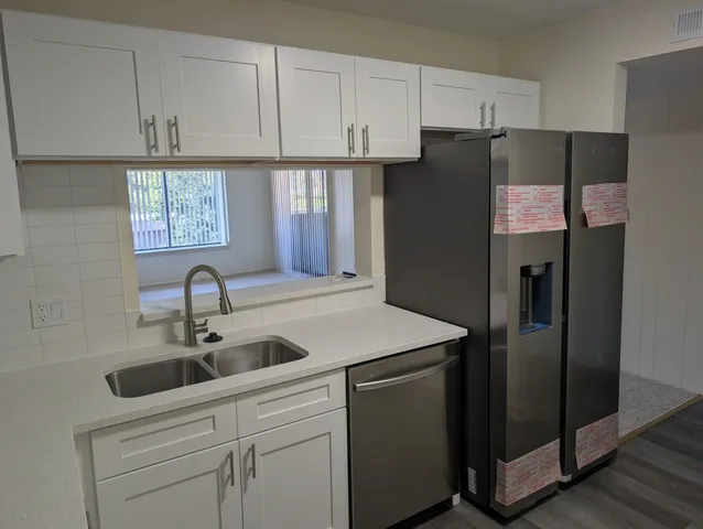 a kitchen with stainless steel appliances granite countertop a refrigerator sink and cabinets