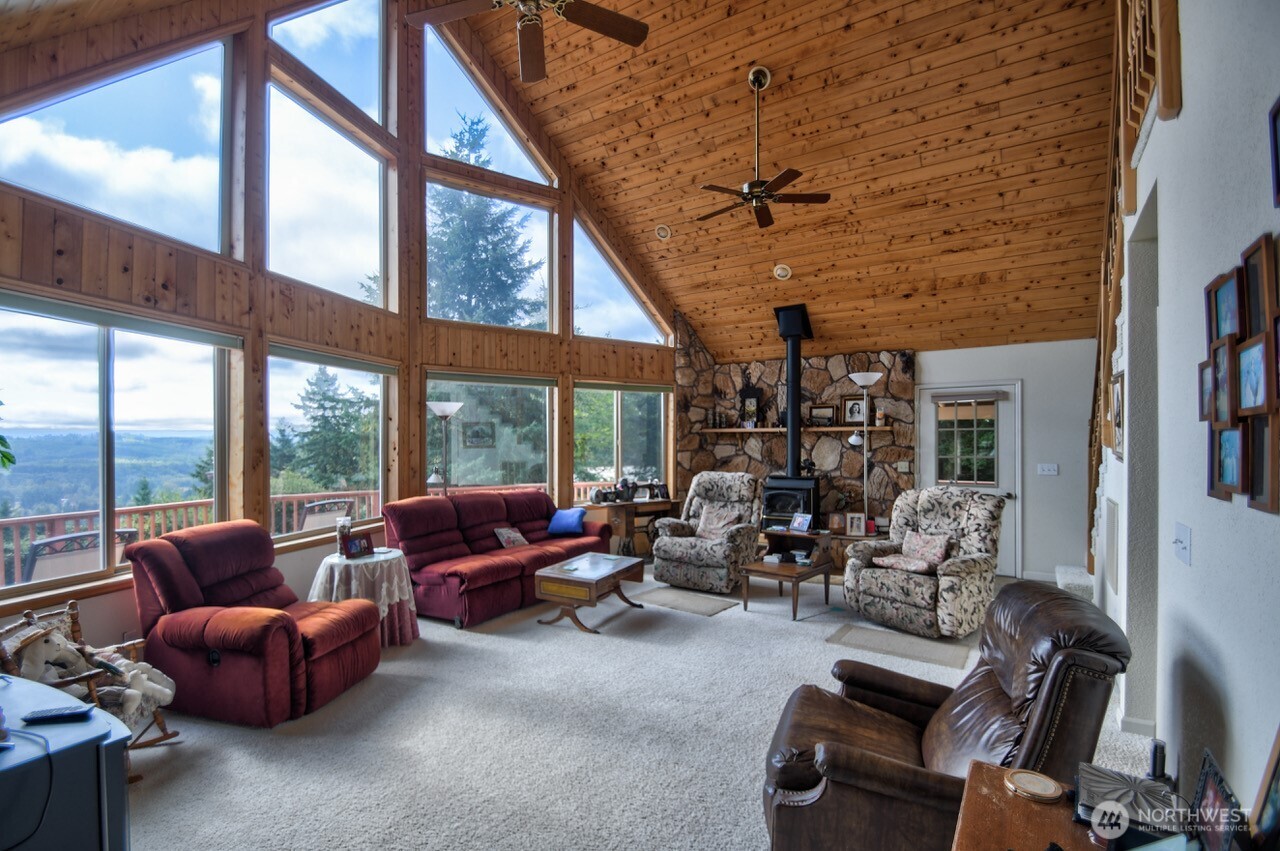 378 Burnt Ridge Road Onalaska, WA 98570 - Photo 3 of 40 a living room with furniture a fireplace and a floor to ceiling window