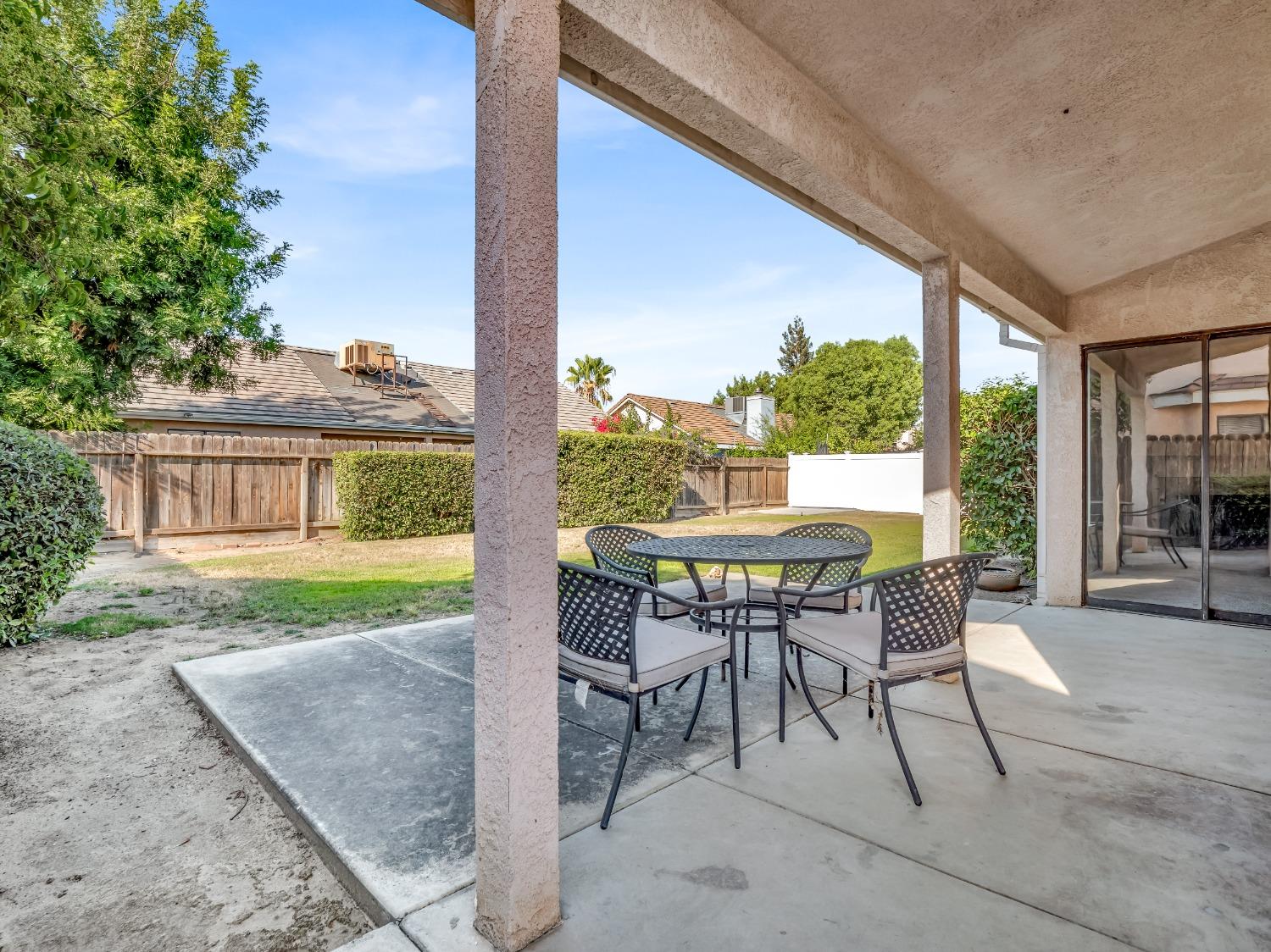 2048 Maple Street Selma, CA 93662 - Photo 15 of 20 a patio with table and chairs and potted plants