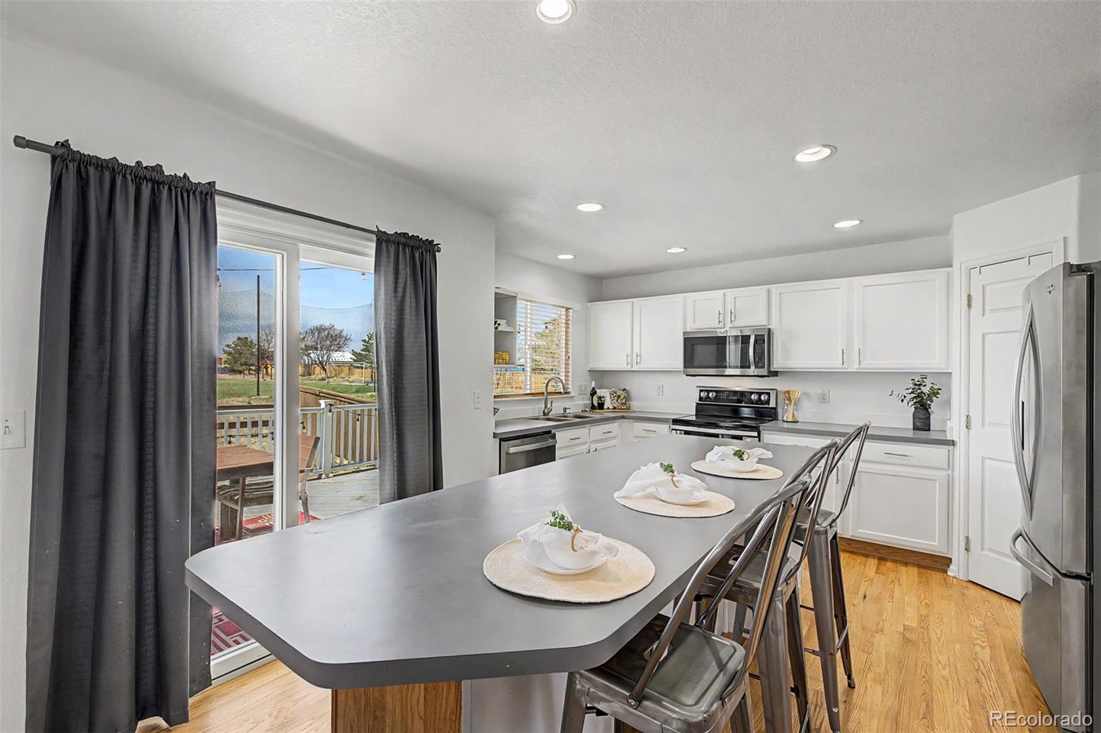 9917 Aftonwood Street Highlands Ranch, CO 80126 - Photo 12 of 48 a dining room with stainless steel appliances a table and chairs