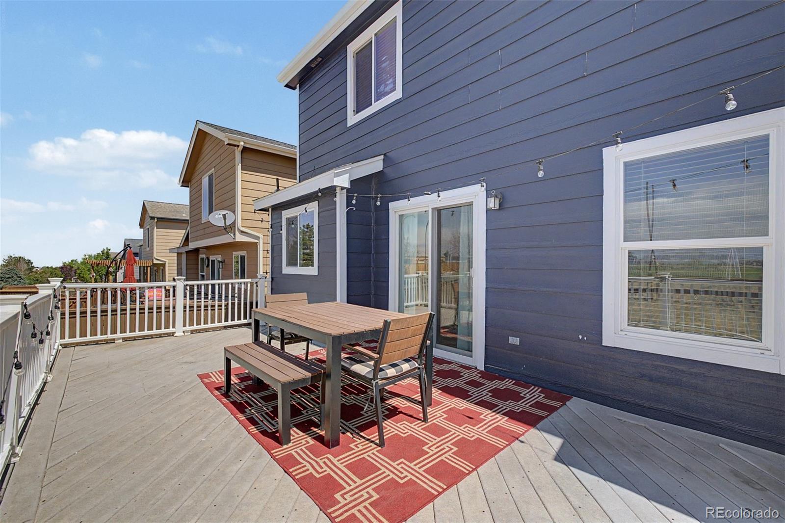 9917 Aftonwood Street Highlands Ranch, CO 80126 - Photo 39 of 48 a view of a patio with table and chairs with wooden floor and fence
