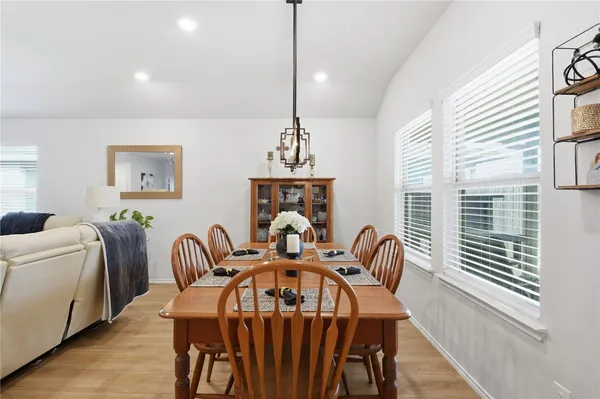 a kitchen with stainless steel appliances kitchen island granite countertop a dining table and chairs