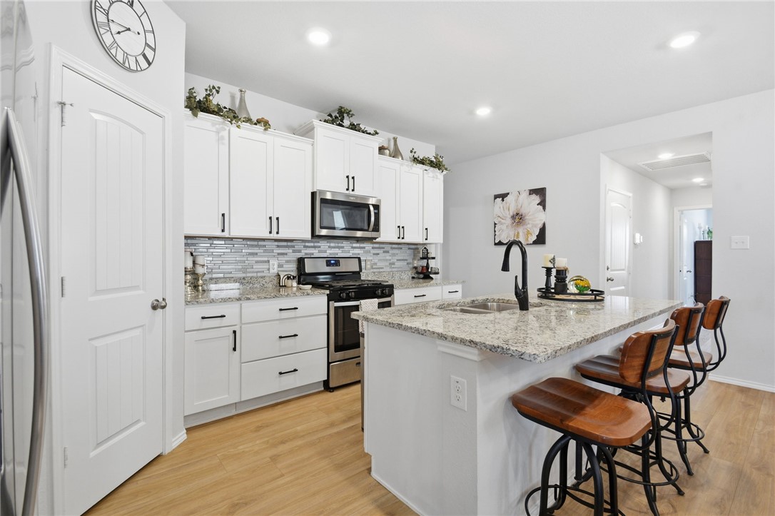2425 Mulligan Lane Navasota, TX 77868 - Photo 18 of 48 a kitchen with white cabinets and stainless steel appliances