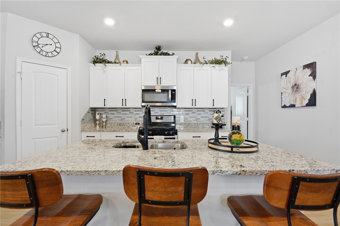 2425 Mulligan Lane Navasota, TX 77868 - Photo 19 of 48 a kitchen with stainless steel appliances kitchen island granite countertop a dining table and chairs