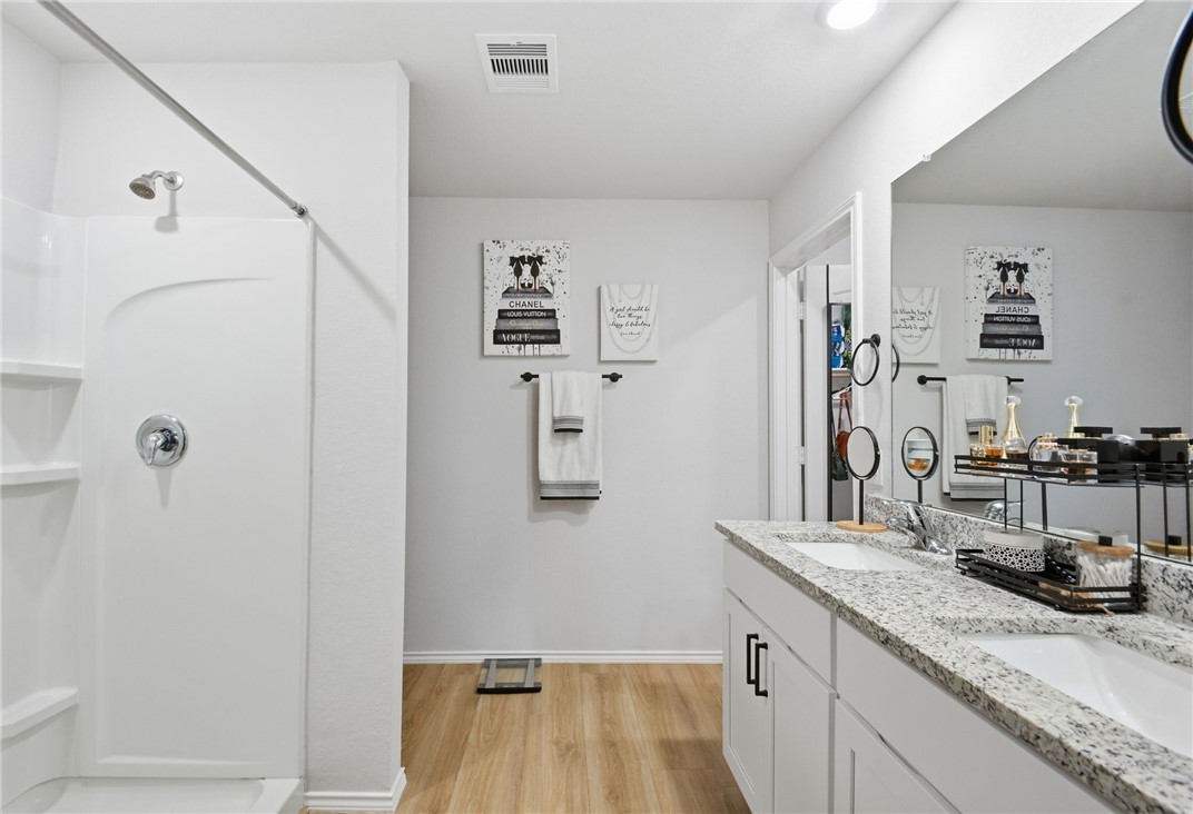 2425 Mulligan Lane Navasota, TX 77868 - Photo 34 of 48 a bathroom with a granite countertop sink a mirror and shower