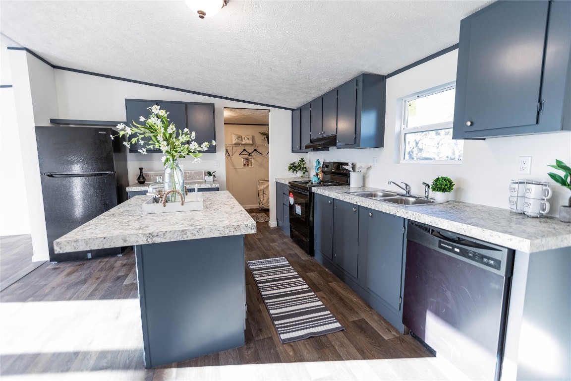 145 Crooked Road Dale, TX 78616 - Photo 4 of 26 a kitchen with stainless steel appliances kitchen island a table chairs in it and wooden floors