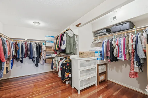 a view of walk in closet with clothes and shoes
