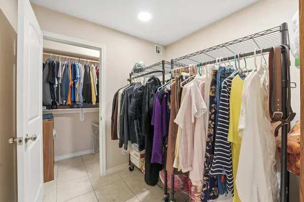 a view of walk in closet with clothes and shoes
