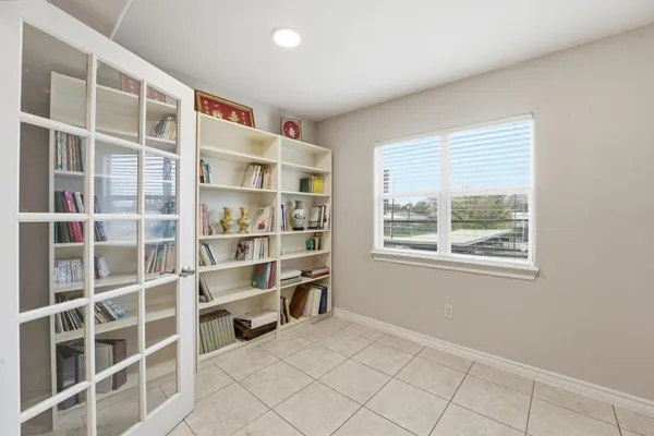 a view of an empty room with a window and cabinet