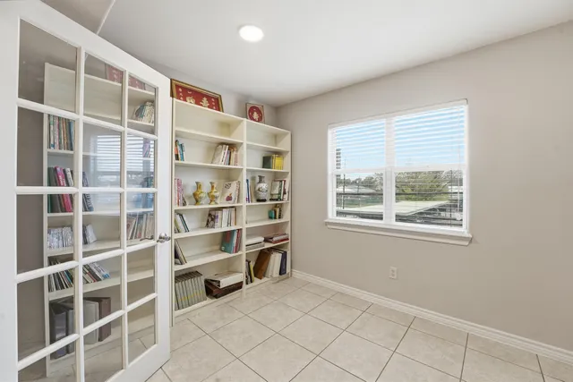 a view of an empty room with a window and cabinet