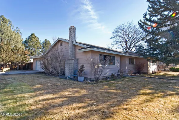 a view of a house with a yard and large tree